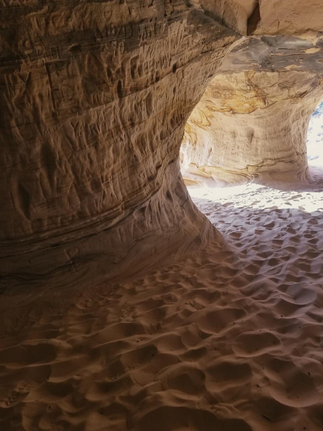 Rippled sand inside a curving sandstone cave